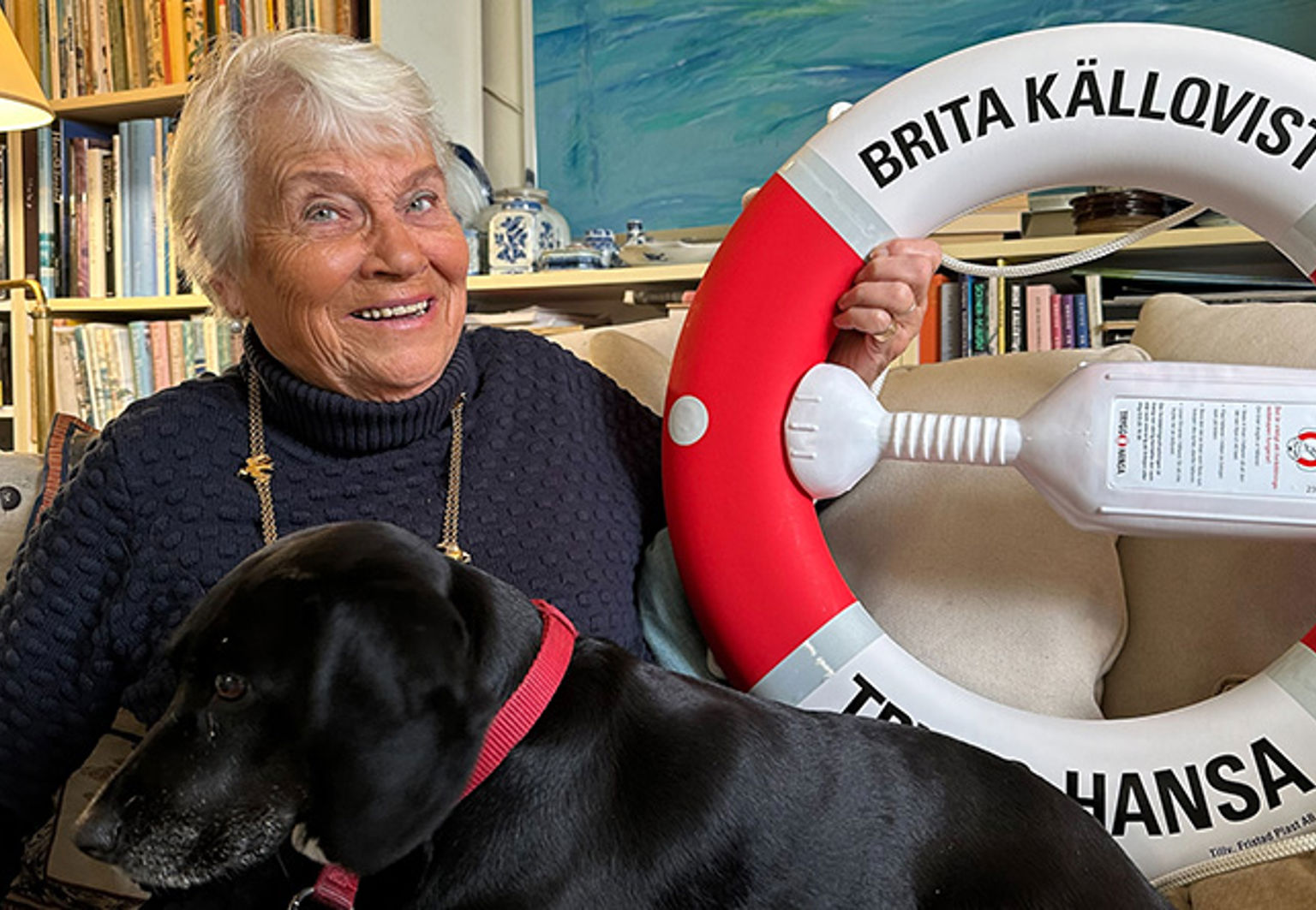 kvinna och labrador med en livboj