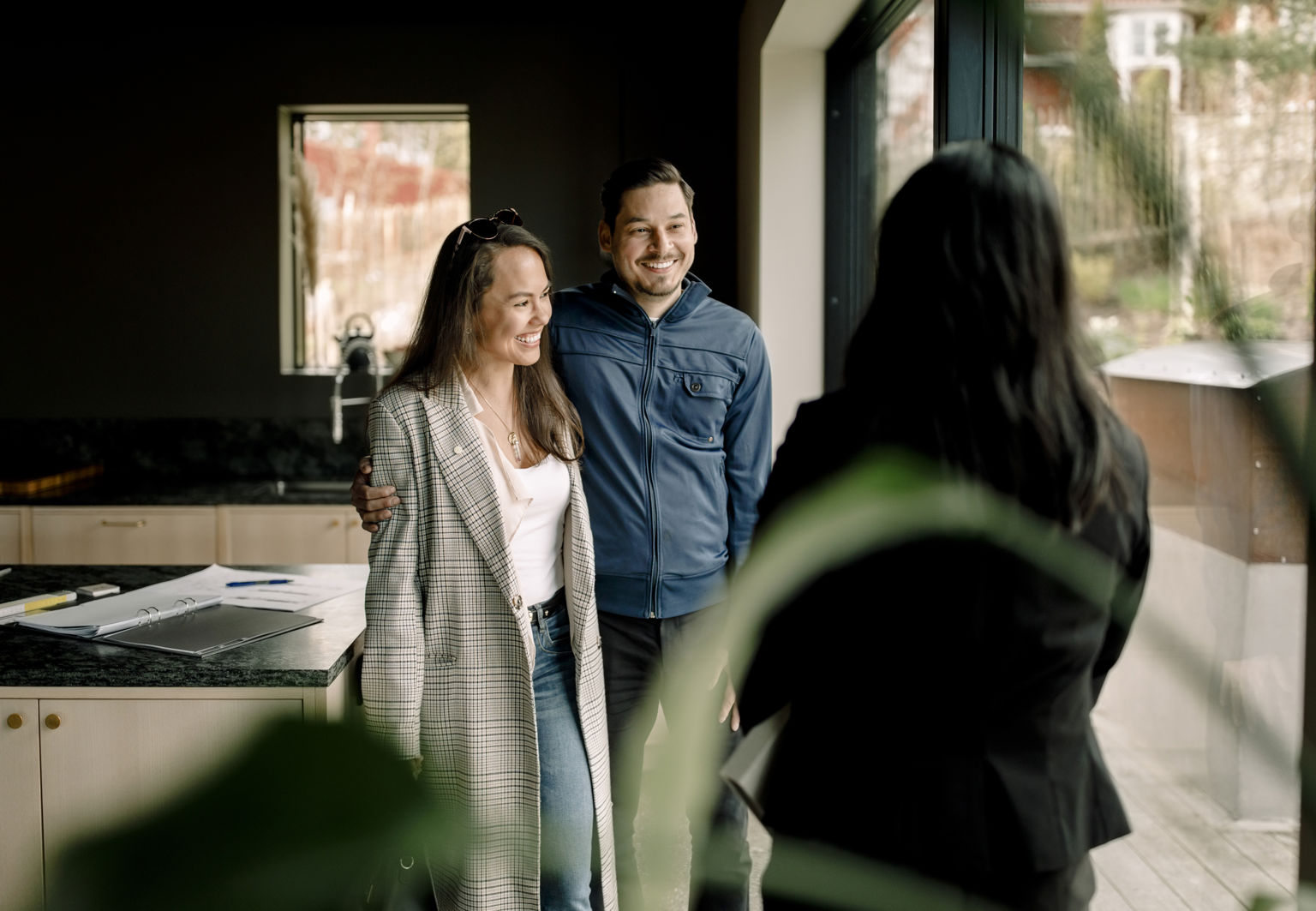Man och kvinna är på visning i ett hus och pratar med en mäklare