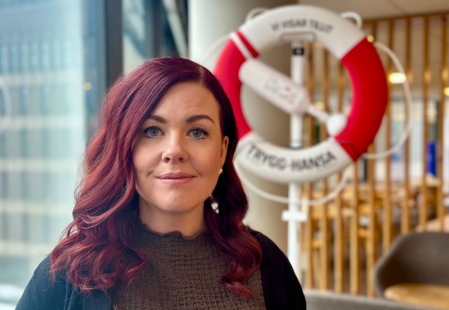 Profilbild på barnmorskan Anna, i bakgrunden syns livboj från Trygg-Hansa