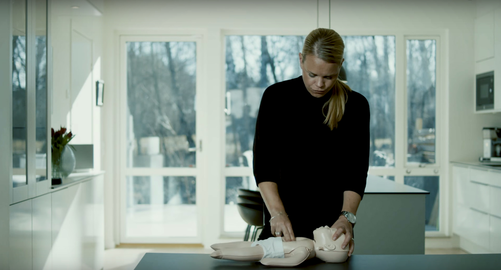 Kvinna utför lungräddning på en HLR-barndocka