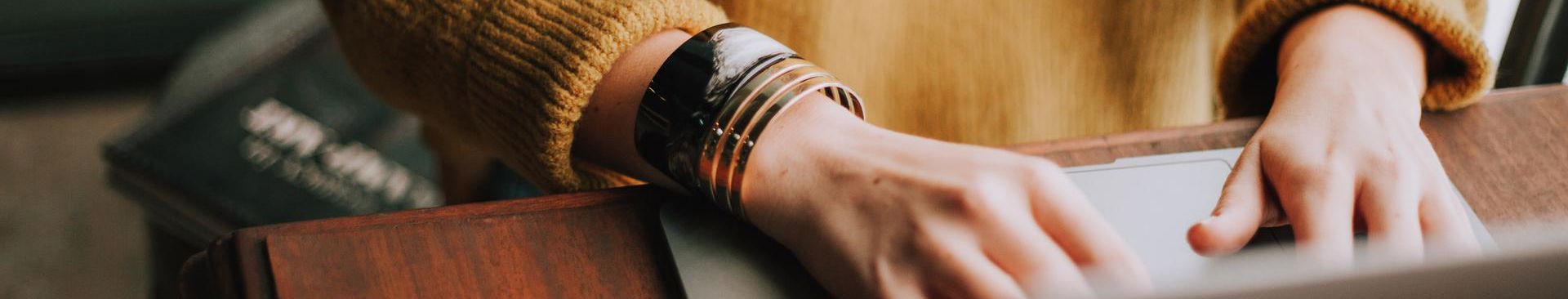 närbild på kvinnas händer jobbar vid datorn