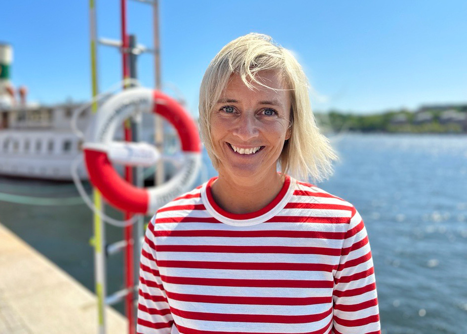 Trygg-Hansas egna vattensäkerhetsexpert Eva står vid kajen framför en livboj