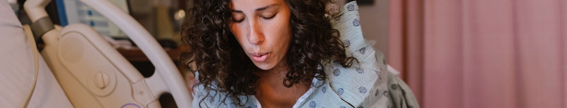 Kvinna andas igenom smärtsamma värkar på förlossingsrummet