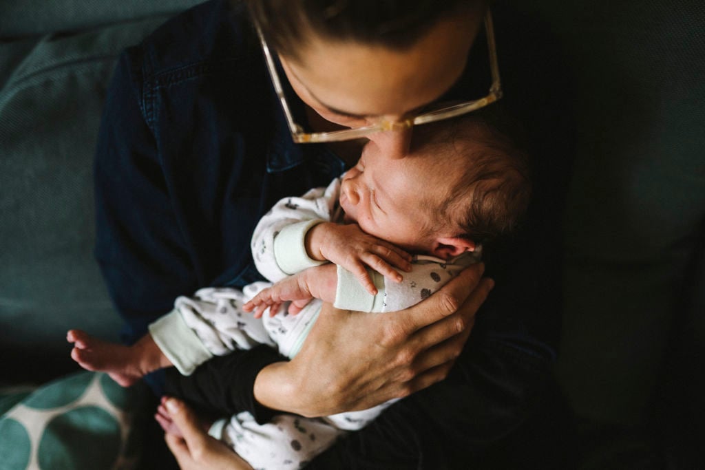 kvinna pussar sin bebis i pannan