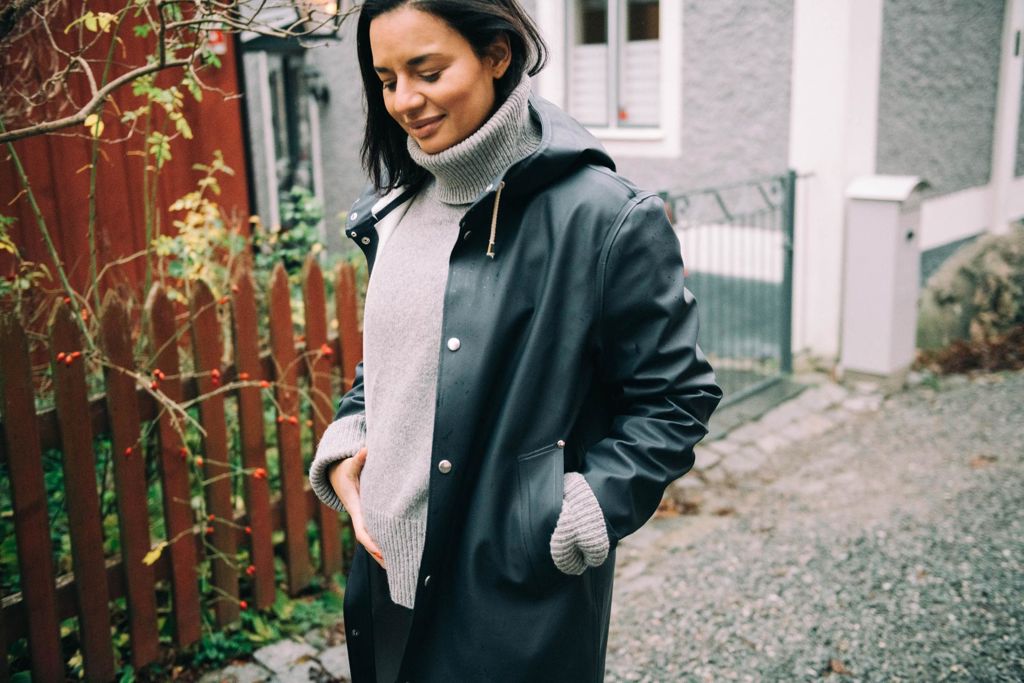 Gravidkvinna på promenad i regnjacka