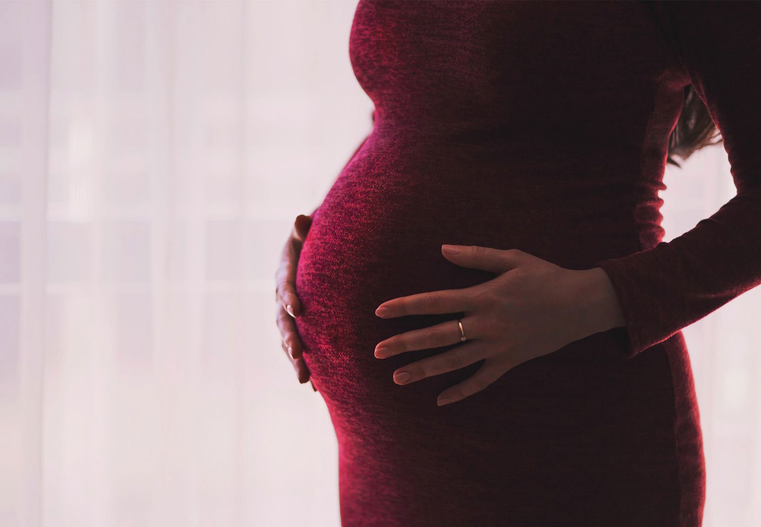 Höggravid kvinna i röd klänning