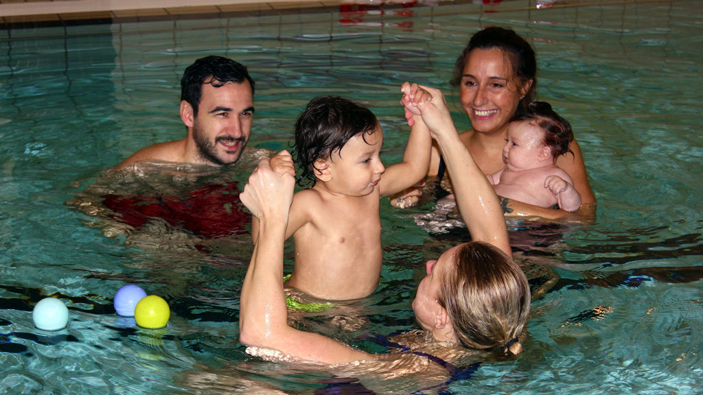 Familj med bebis i en pool inomhus