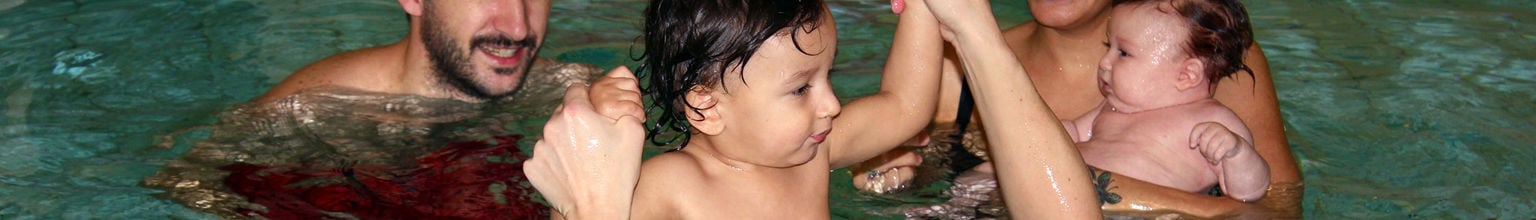 Familj med bebis i en pool inomhus