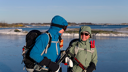 Två pensionärer ute på isen med utrustning