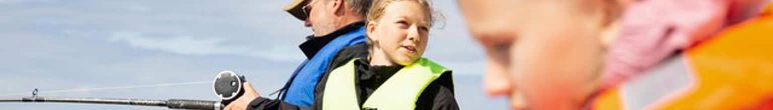 Barn och en vuxen fiskar från en båt