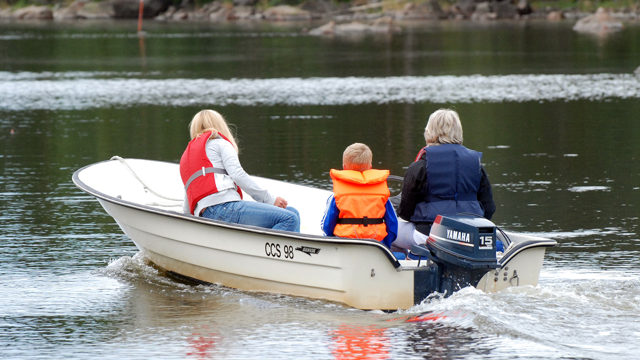 Familj på utflykt i liten motorbåt