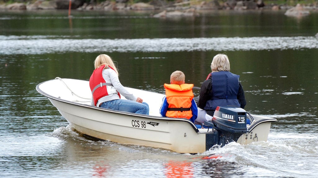 Familj på utflykt i liten motorbåt