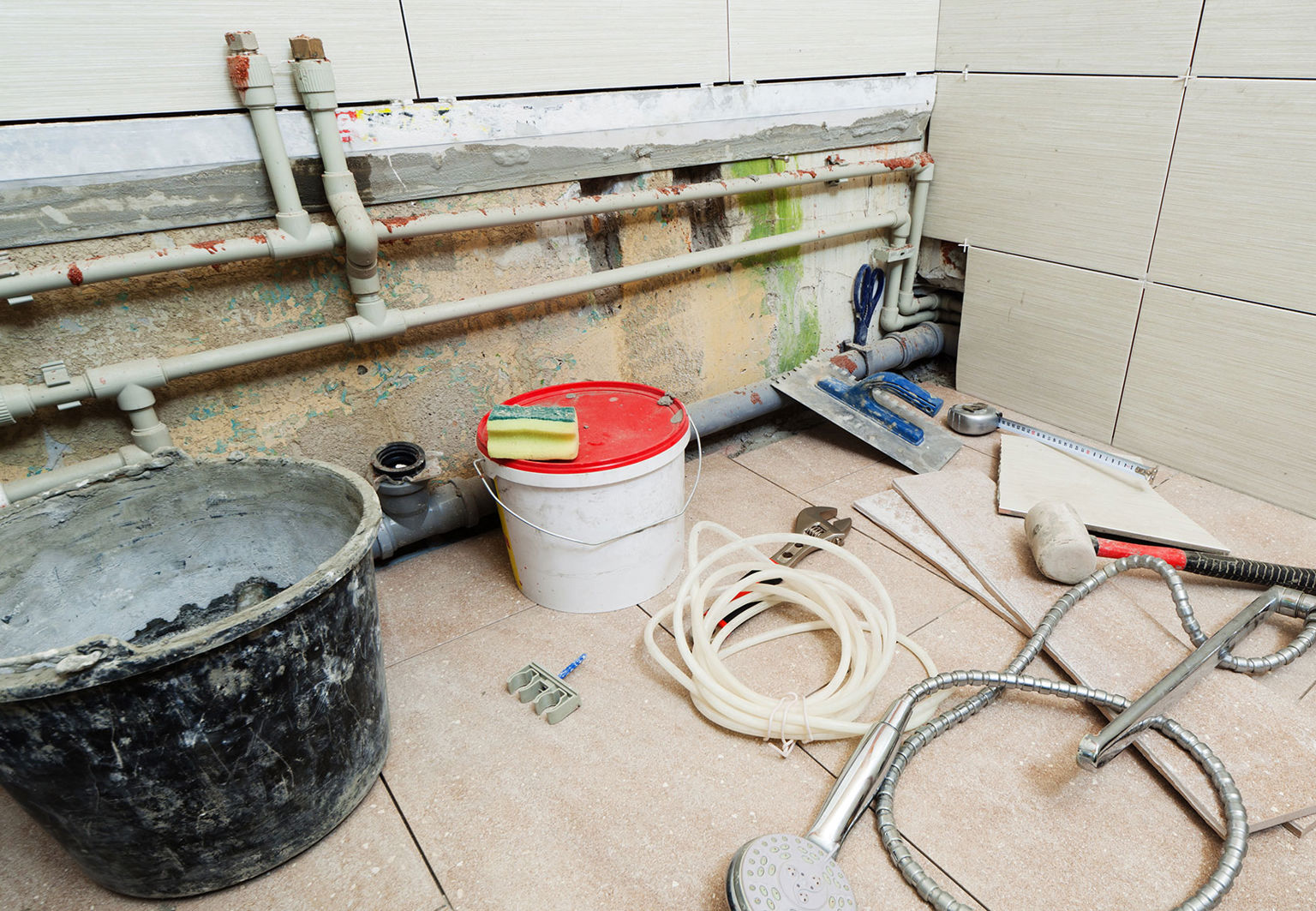 Hinkar och andra redskap på golvet i en pågående renovering