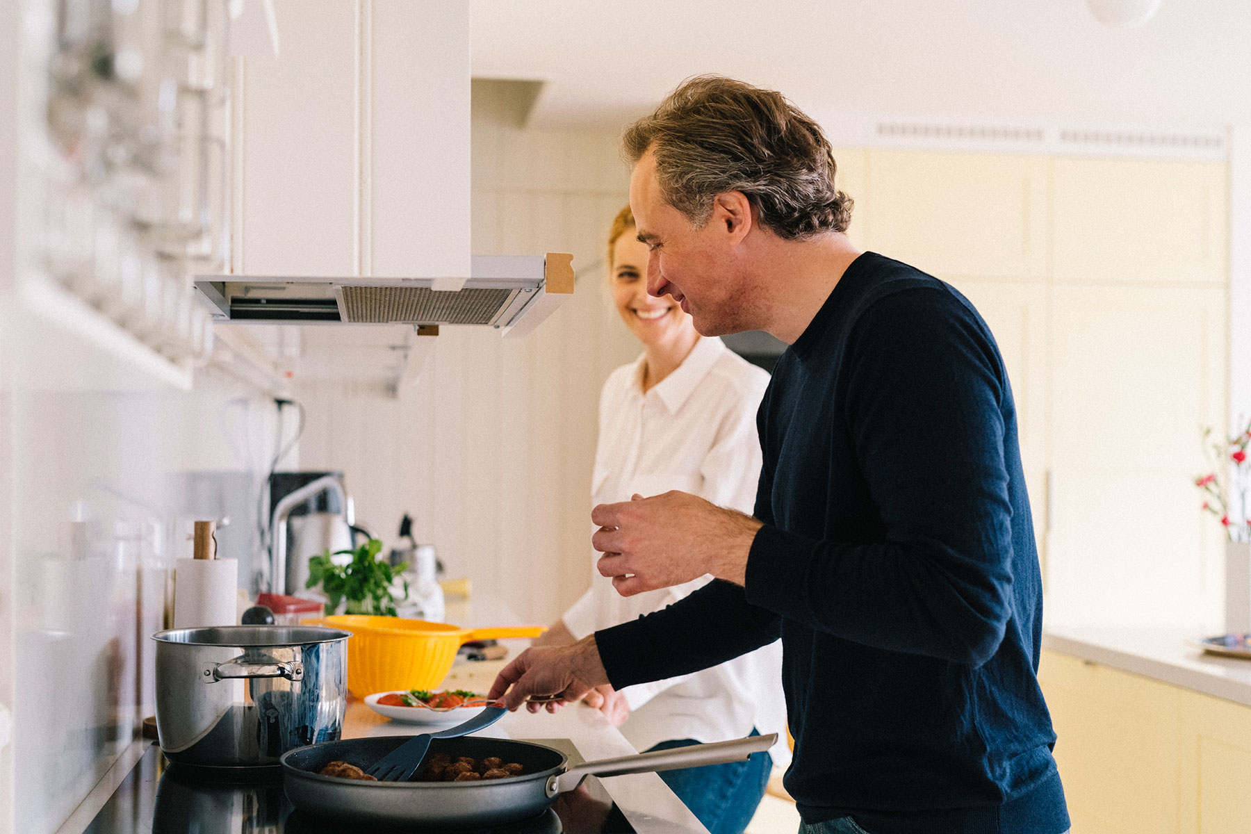 Kvinna och man lagar mat i ett modernt kök