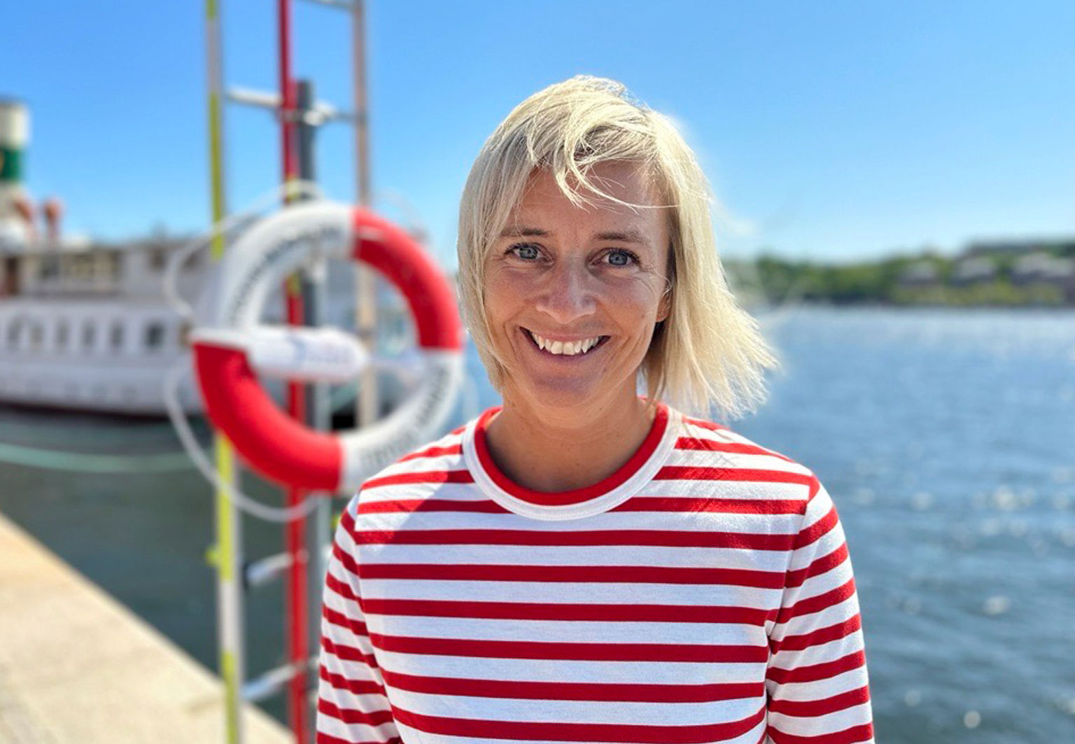 Trygg-Hansas egna vattensäkerhetsexpert Eva står vid kajen framför en livboj