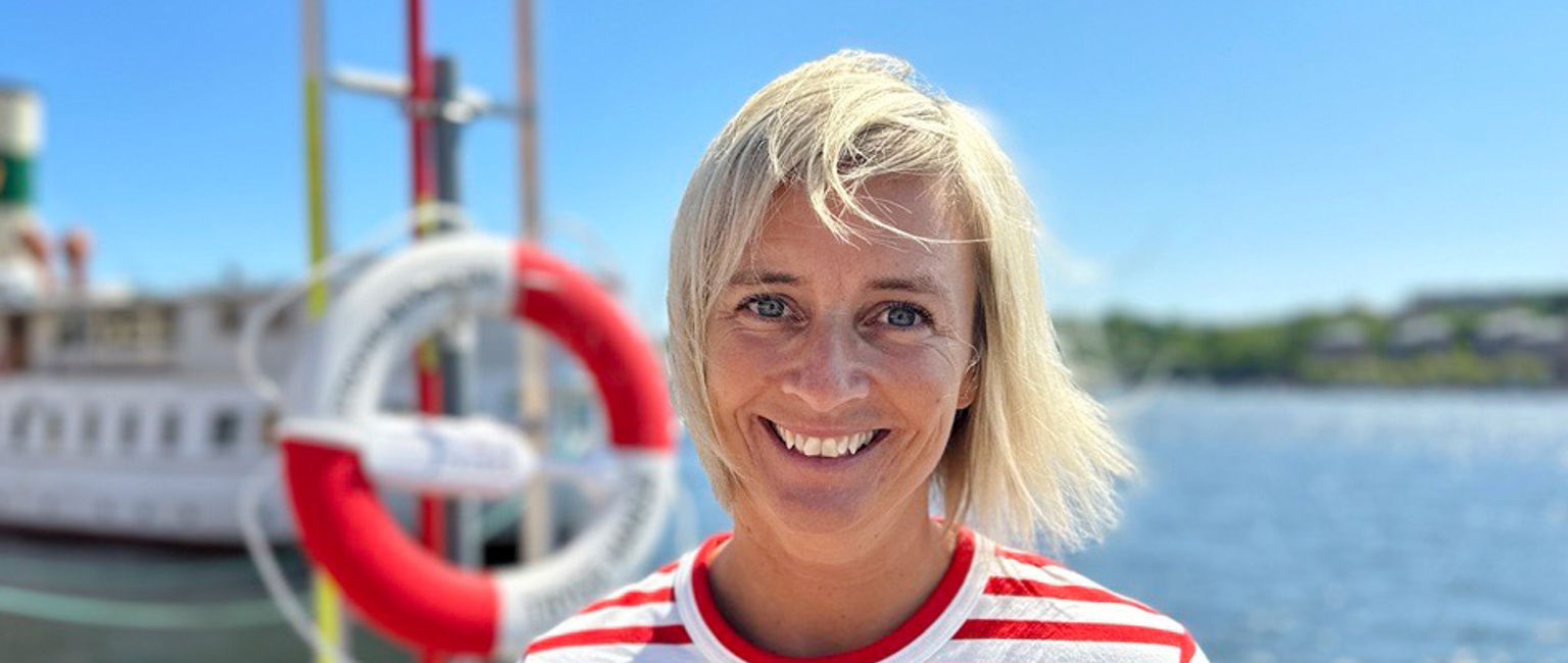 Trygg-Hansas egna vattensäkerhetsexpert Eva står vid kajen framför en livboj