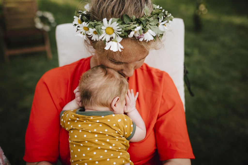 Mamma med midsommarkrans myser med sin bebis