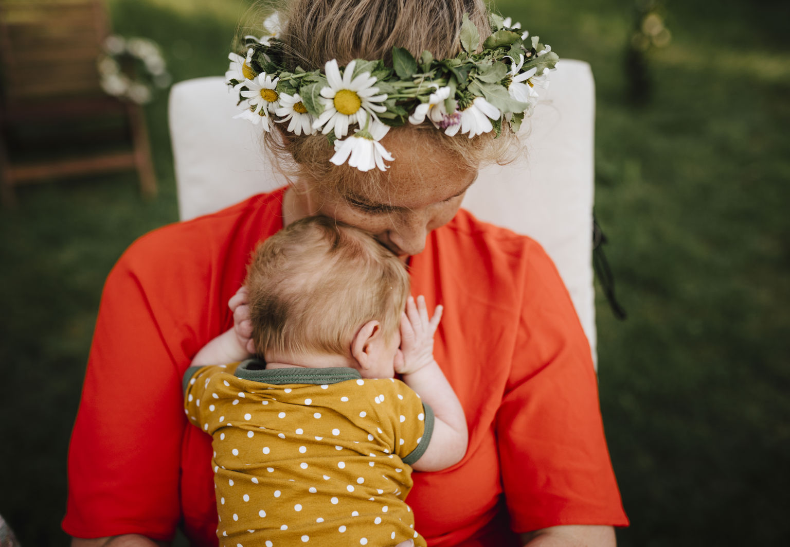 Mamma med midsommarkrans myser med sin bebis