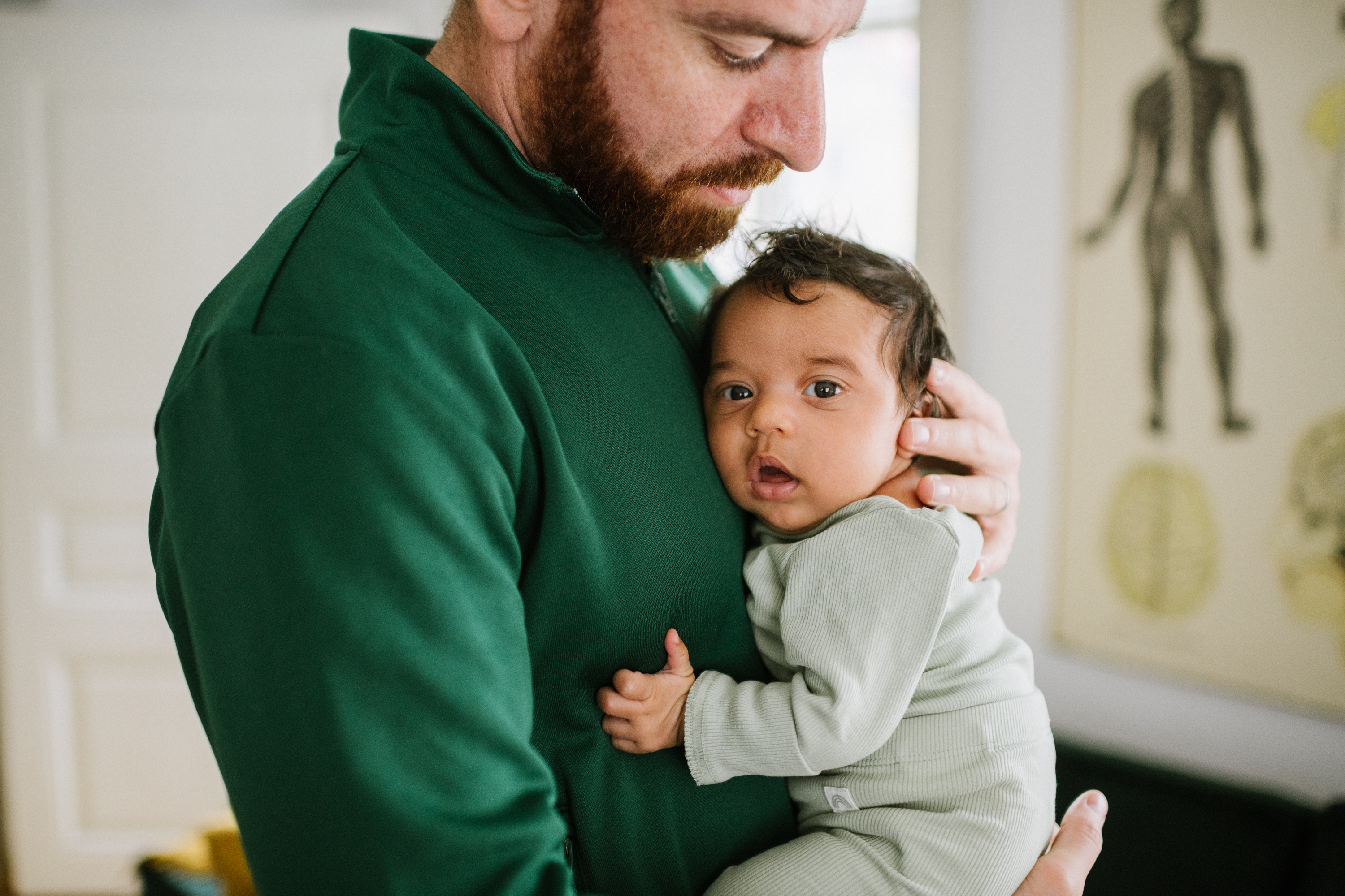 Pappa håller i en vaken bebis och stöttar bebisens huvud