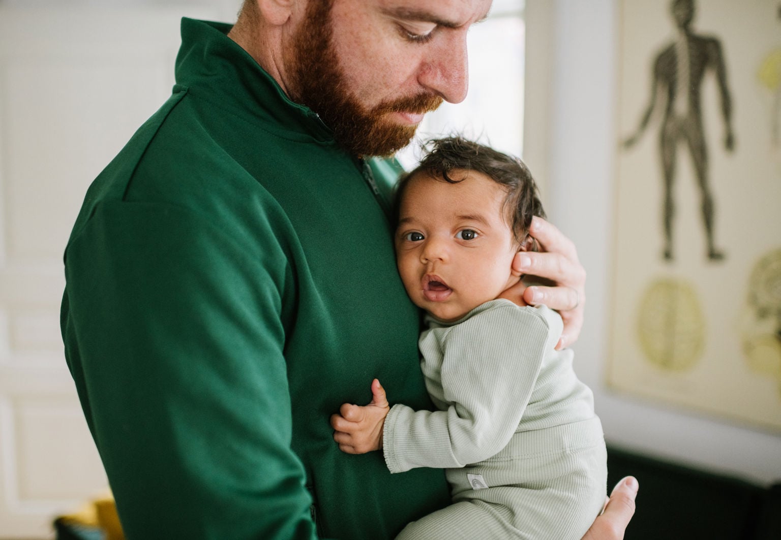 Pappa håller i en vaken bebis och stöttar bebisens huvud