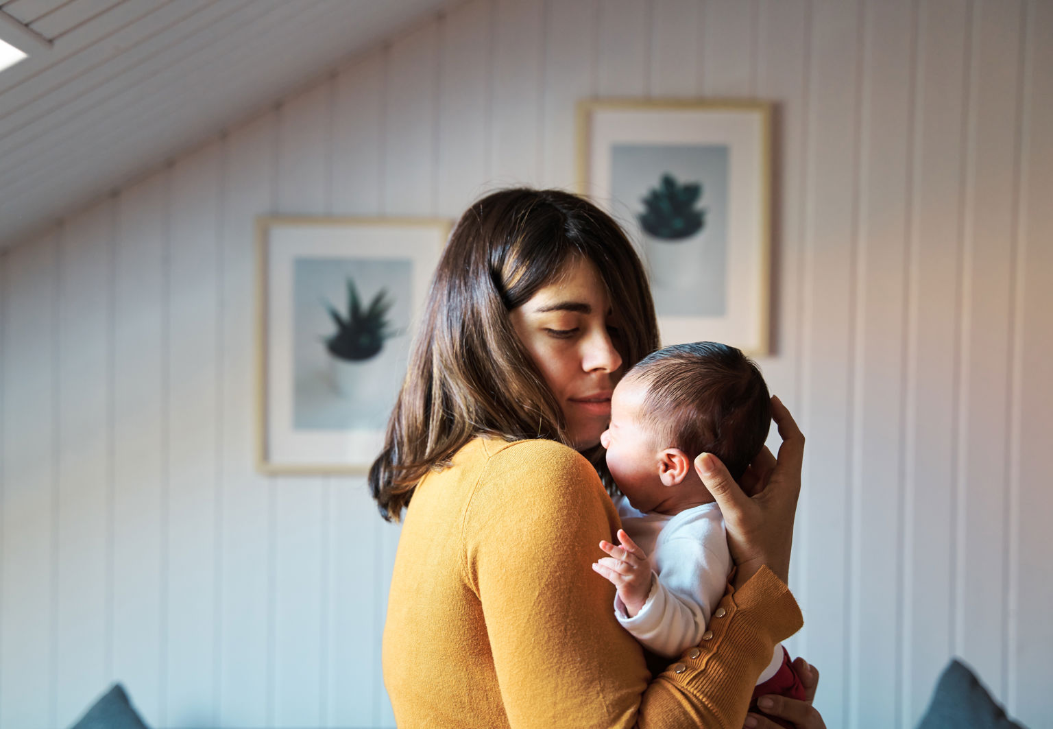 Mamma håller om och tittar på sin nyfödda bebis i hemmamiljö