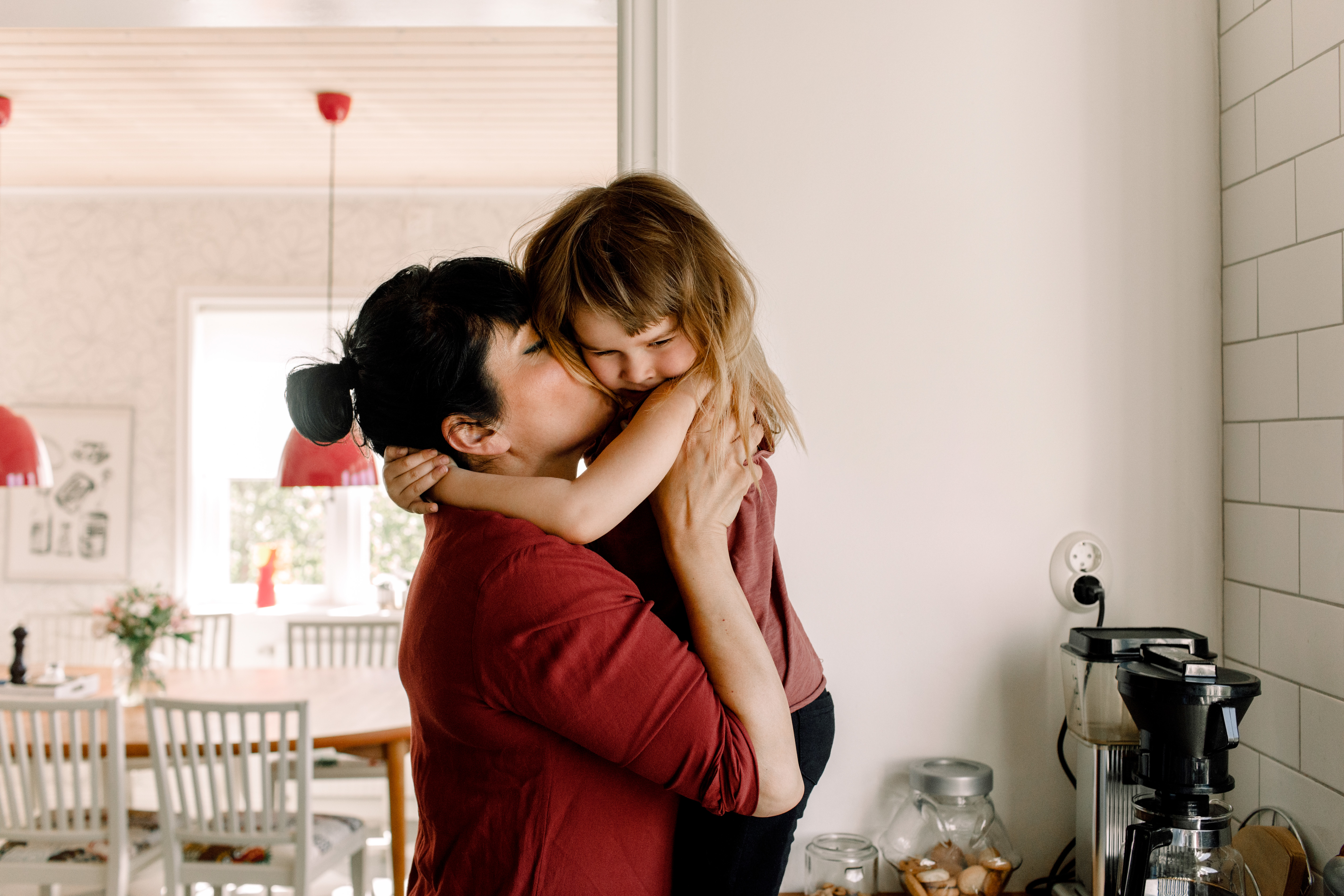 Mamma och dotter kramas i köket