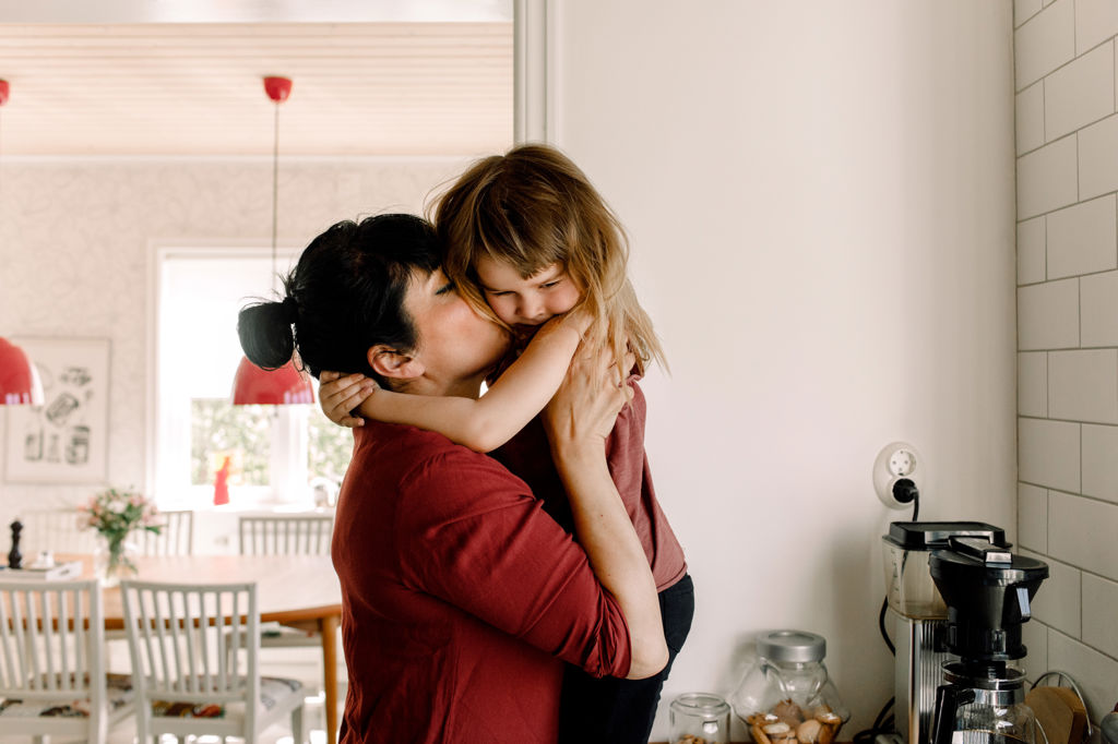 Mamma och dotter kramas i köket