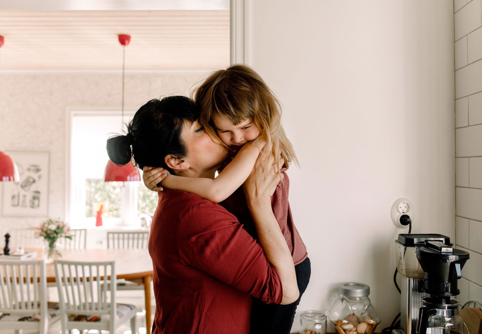 Mamma och dotter kramas i köket