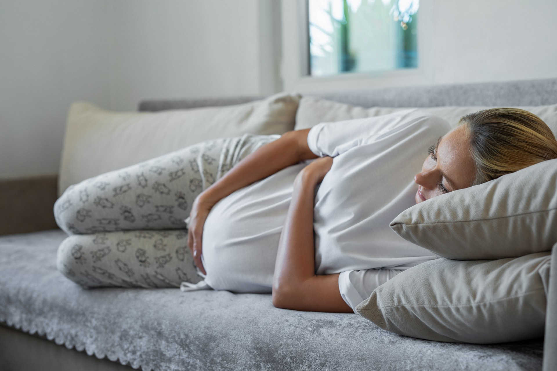 Gravid kvinna ligger i en soffa