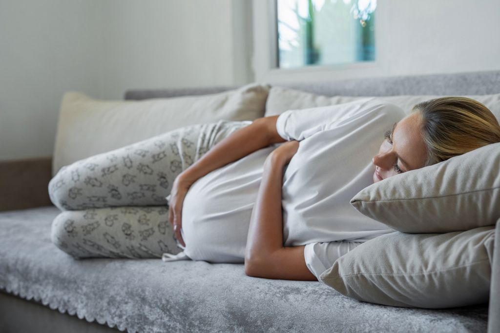 Gravid kvinna ligger i en soffa