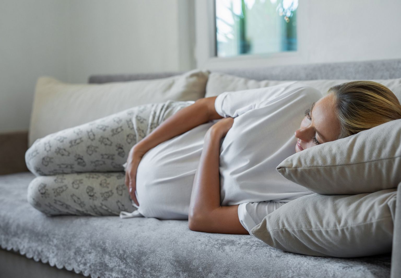 Gravid kvinna ligger i en soffa