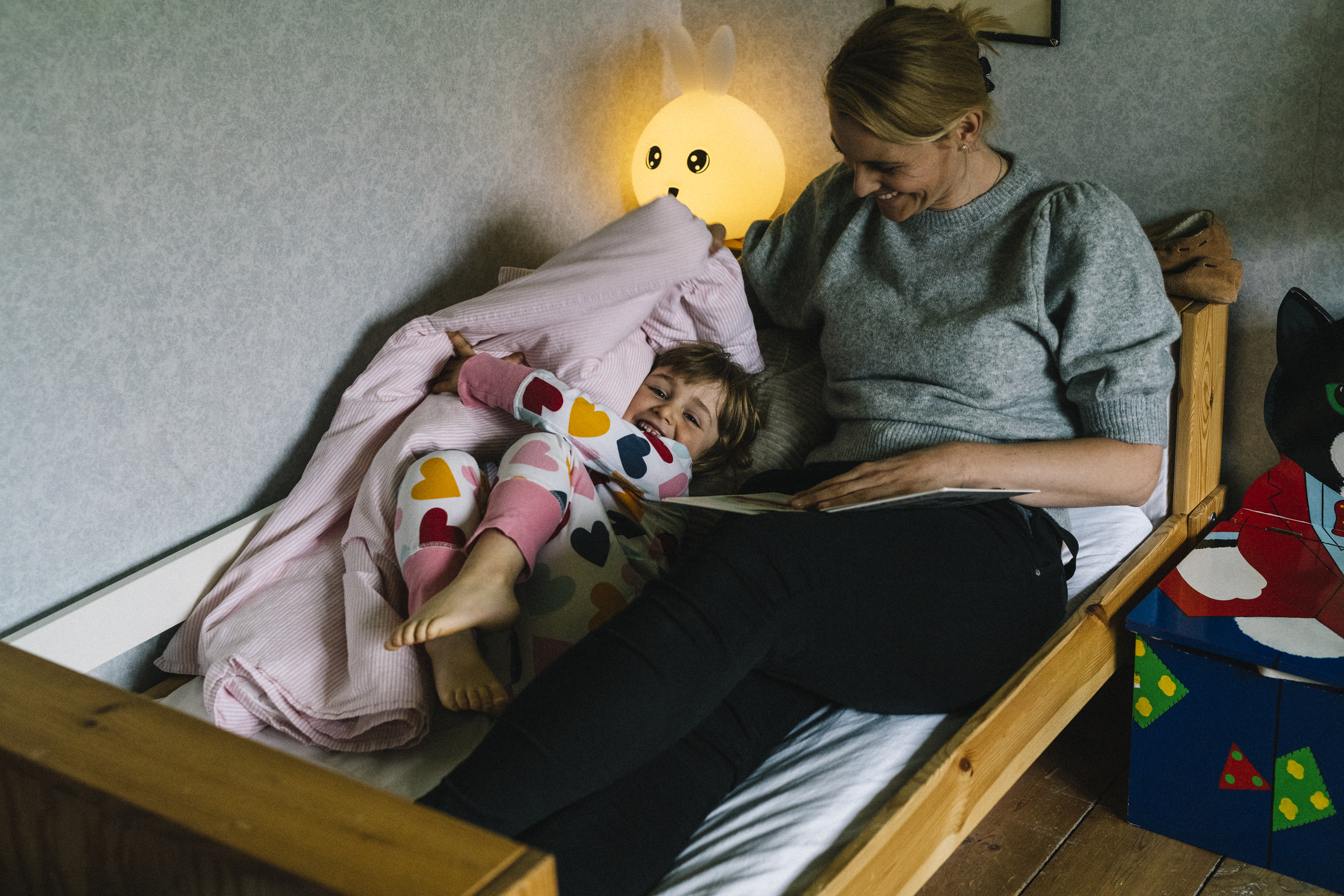 Mamma sitter bredvid sitt barn i en barnsäng