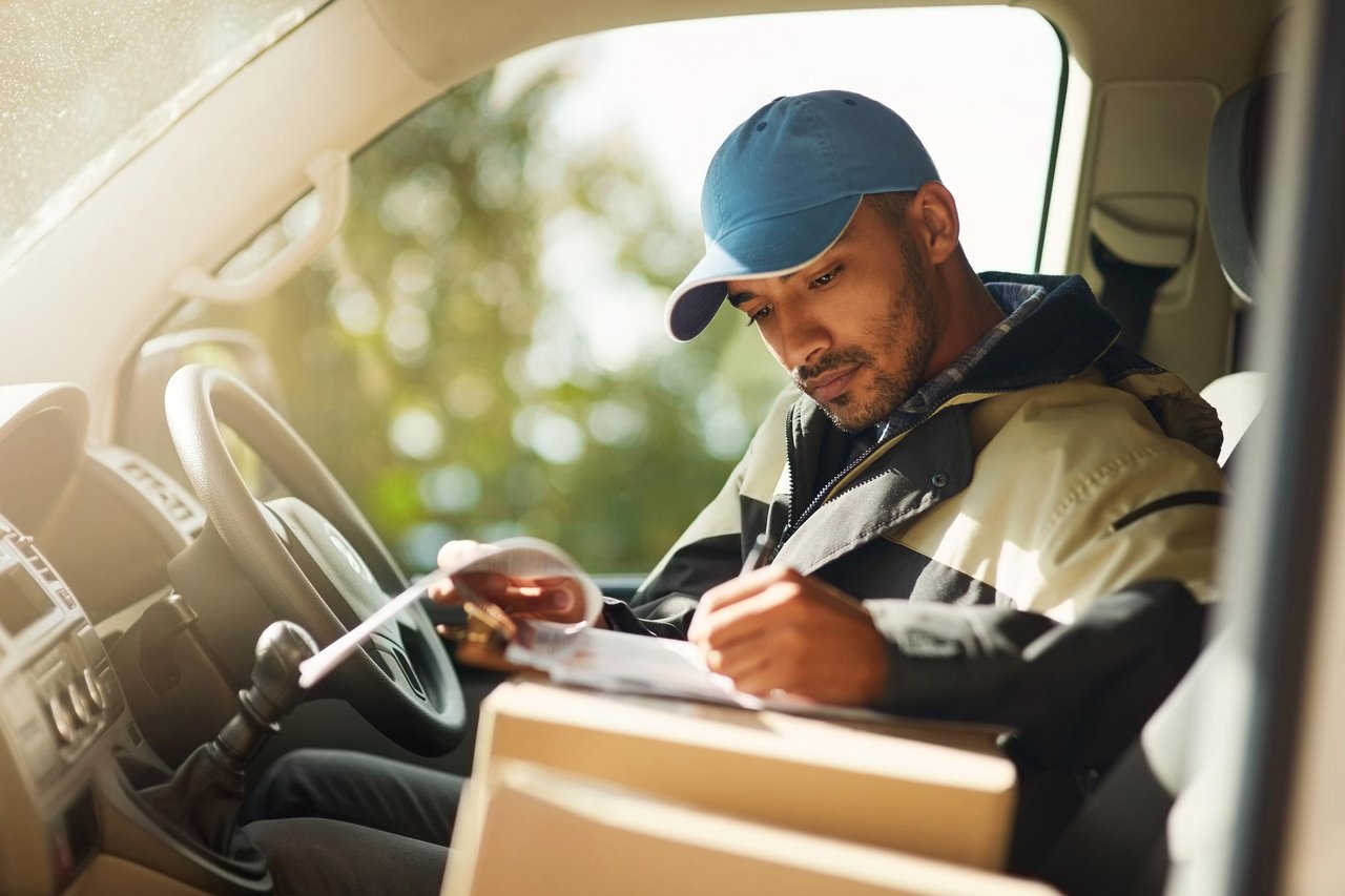 företagare sitter i sin bil och granskar en faktura