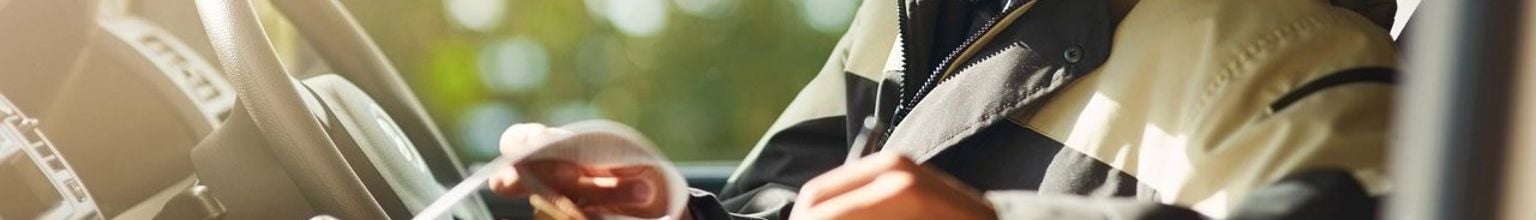 företagare sitter i sin bil och granskar en faktura