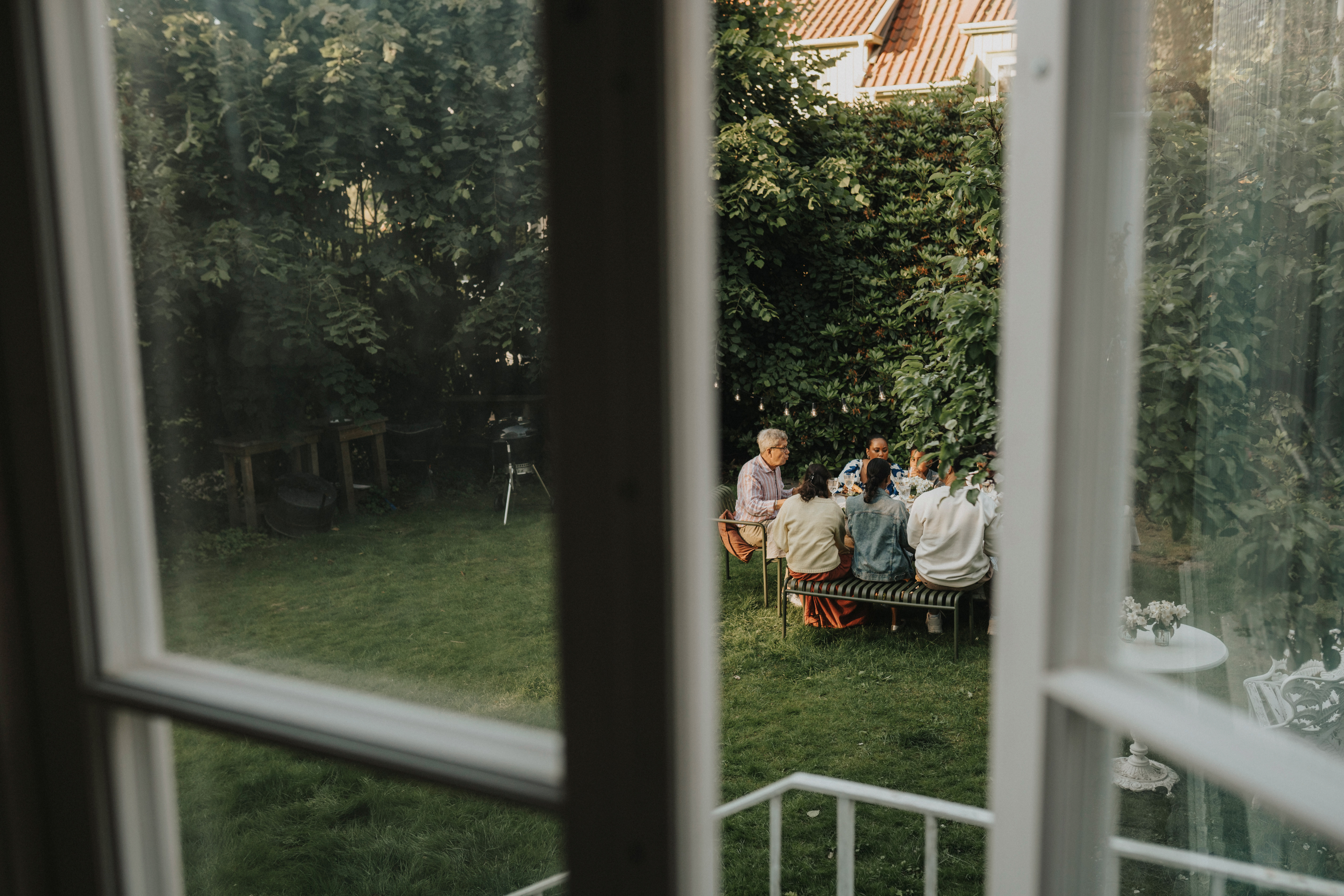 Ett gäng vuxna sitter och äter ute i trädgården