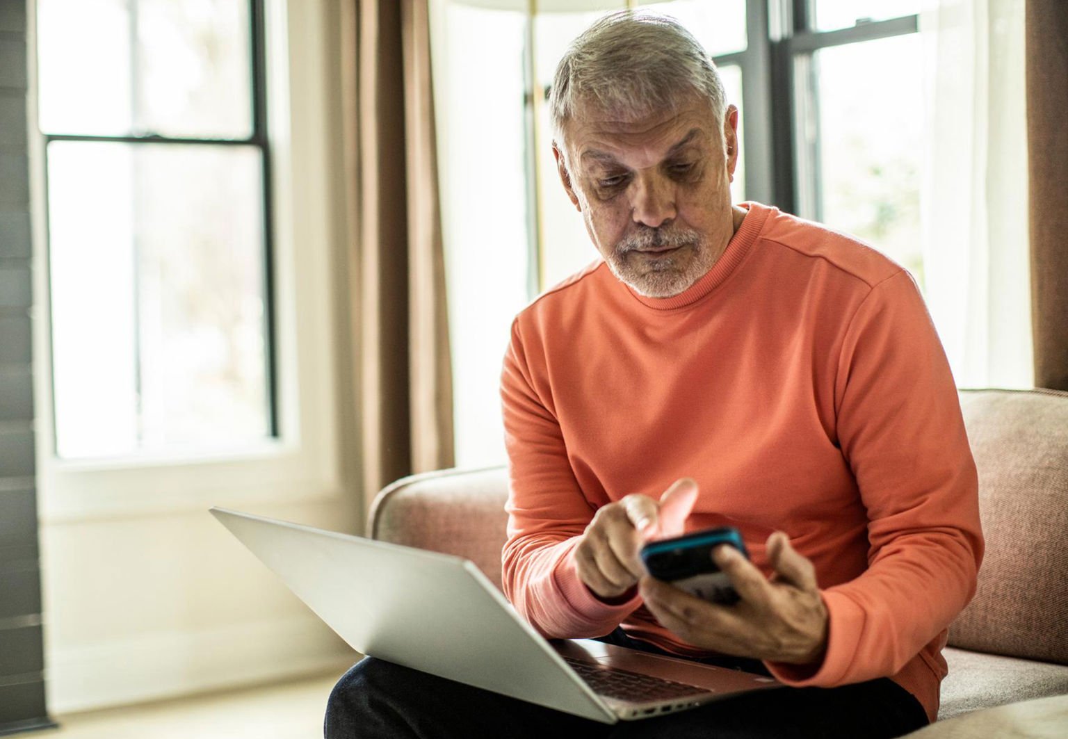 man med laptop och mobil