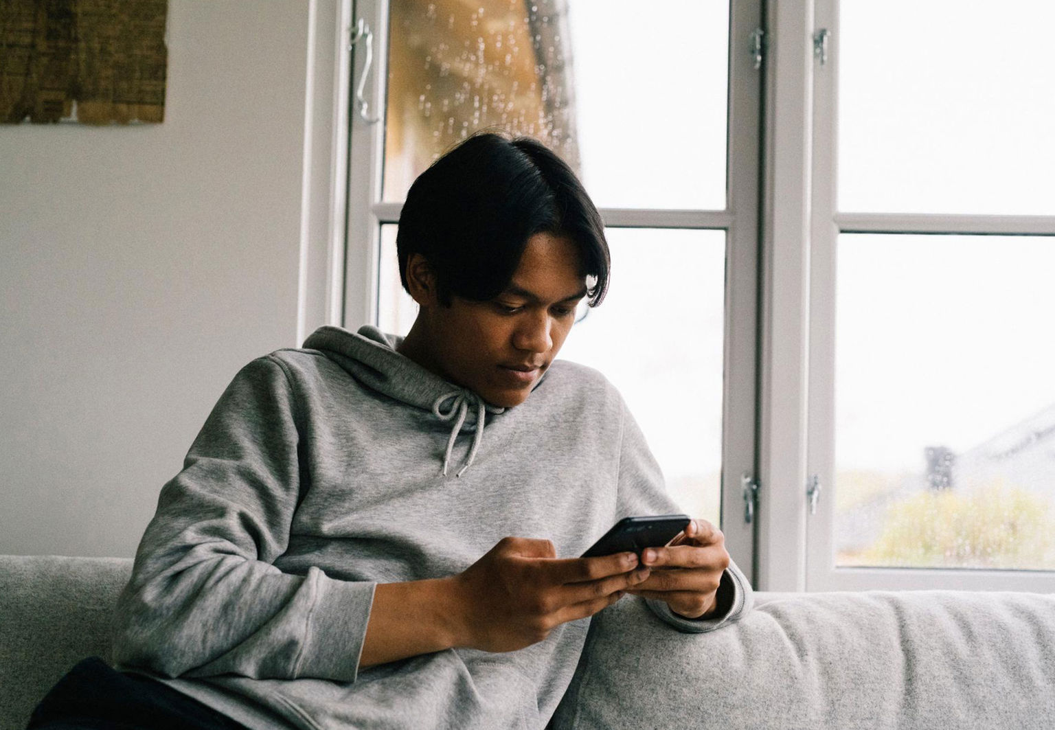 pojke tonåring kollar på mobilen