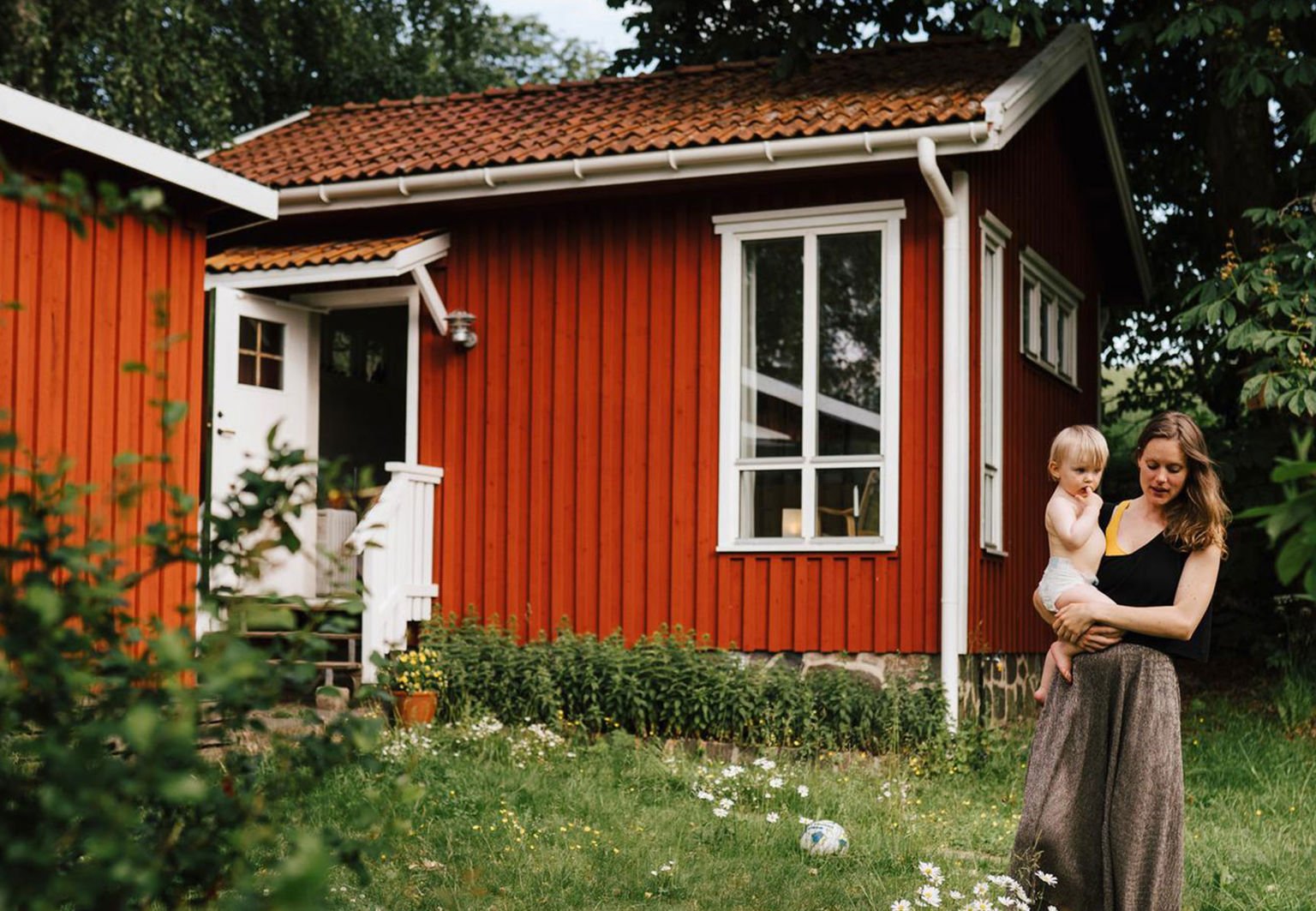 kvinna och barn utanför sitt sommarhus