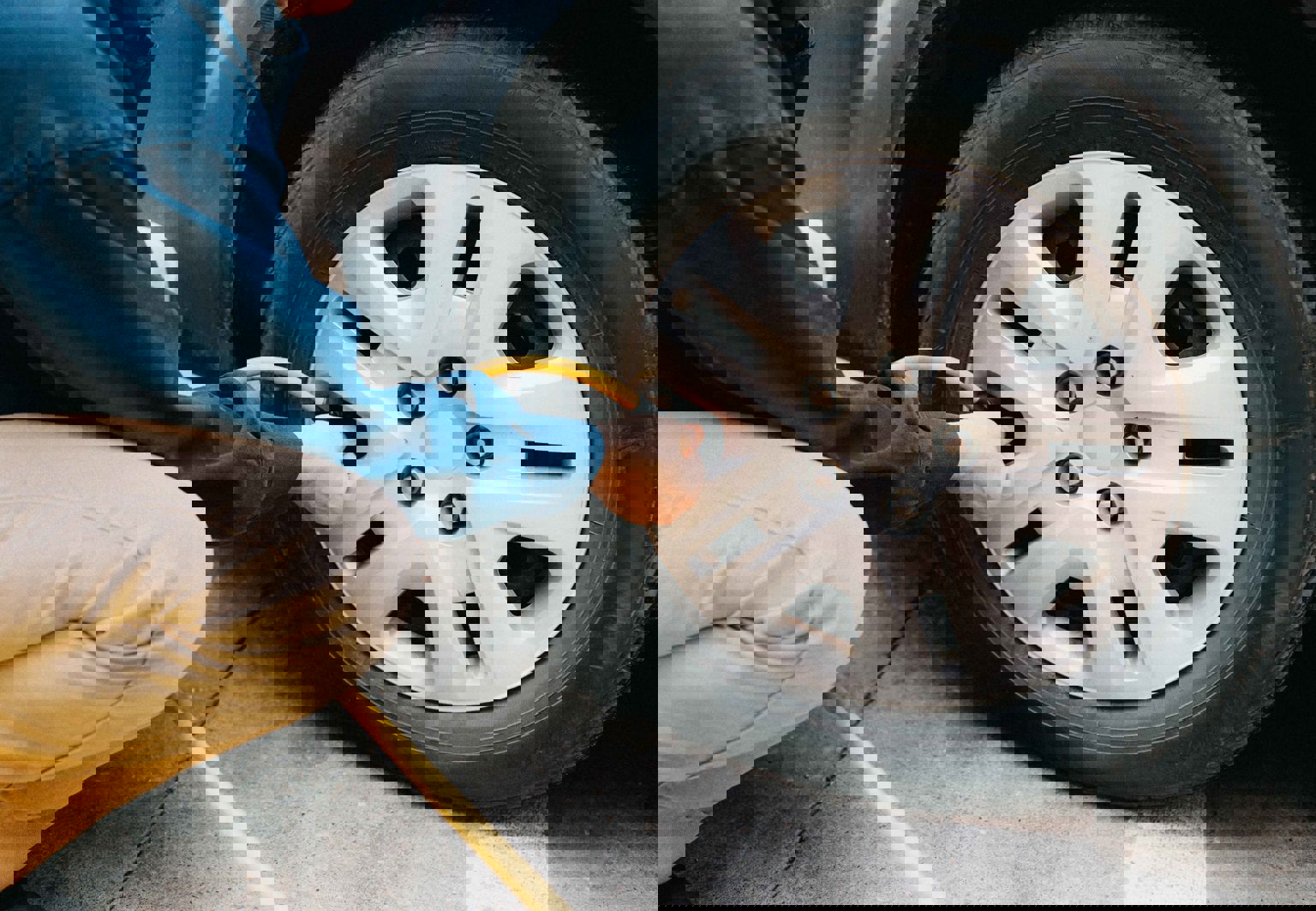 En man fyller på luft i sitt bildäck med en slang