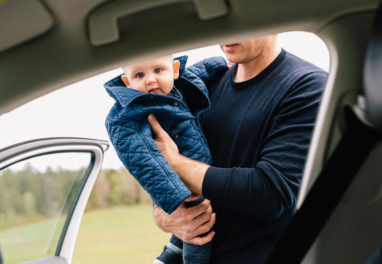 man ska sätta ett litet barn i bilen
