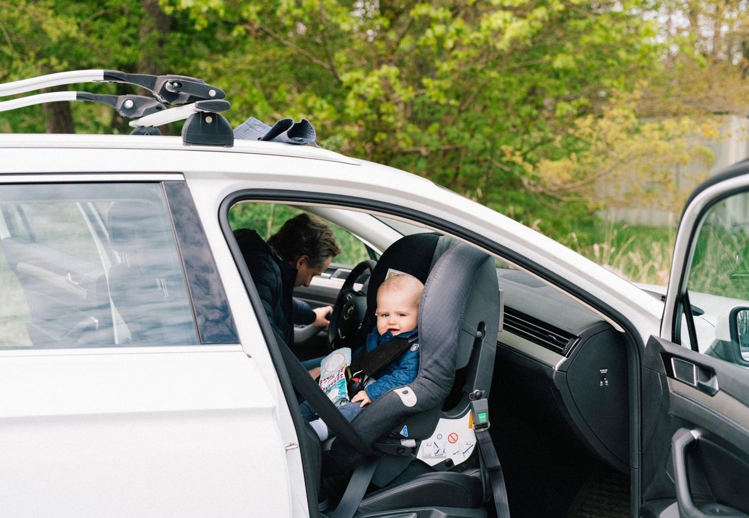 Bebis sitter bakåtvänd i en bilbarnstol i passagerarsätet fram