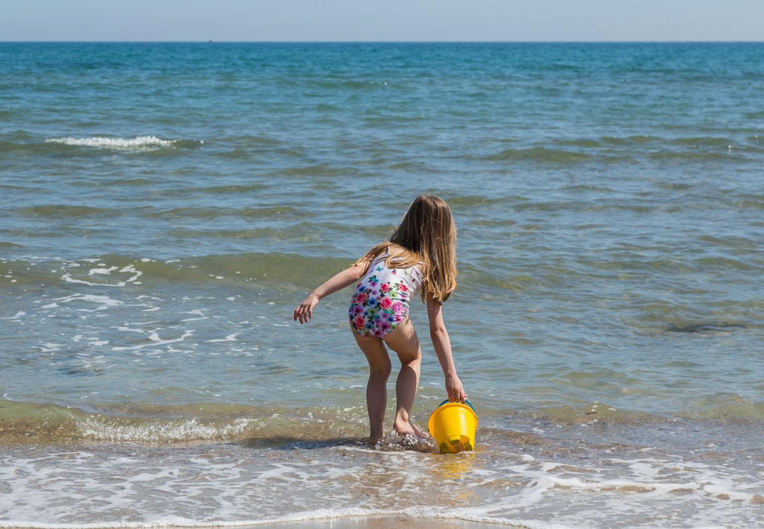 liten flicka leker i vattenbrynet