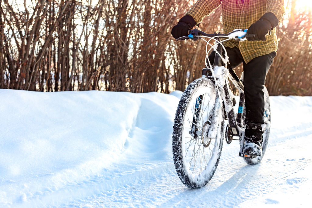Man cyklar på en snöig väg