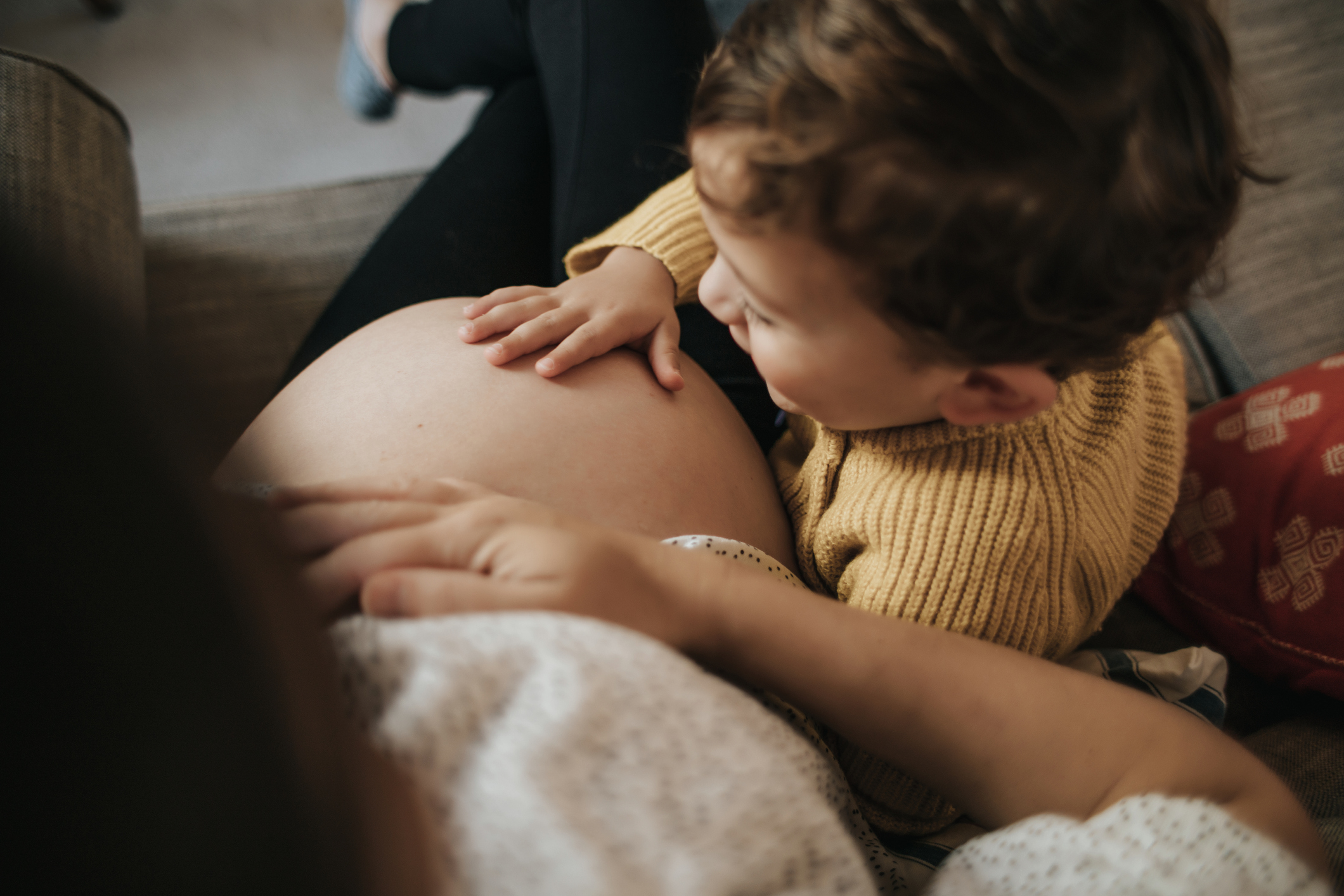 litet barn klappar på gravid mammas mage
