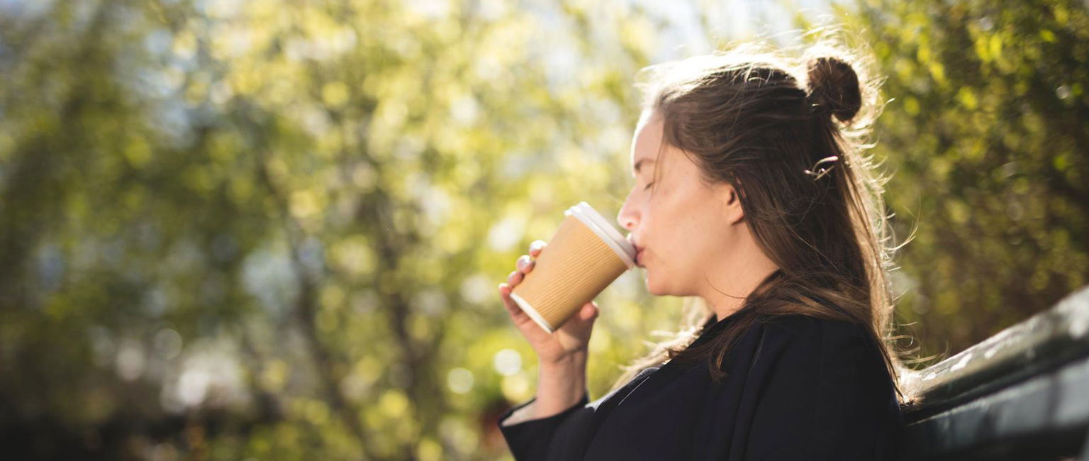 ung kvinna gravid på en parkbänk i solen