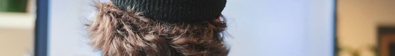 Man med mössa arbetar på stor skärm