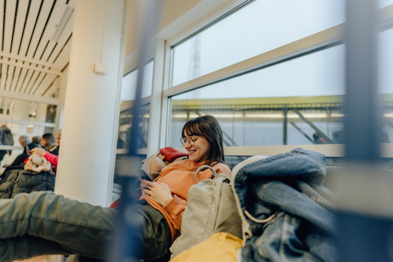 ung tjej sitter på flygplats väntar på sitt flyg