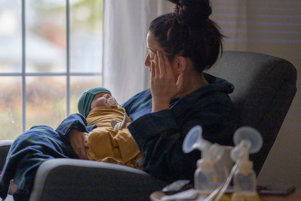 kvinna sitter med en bebis i knät i en fåtölj