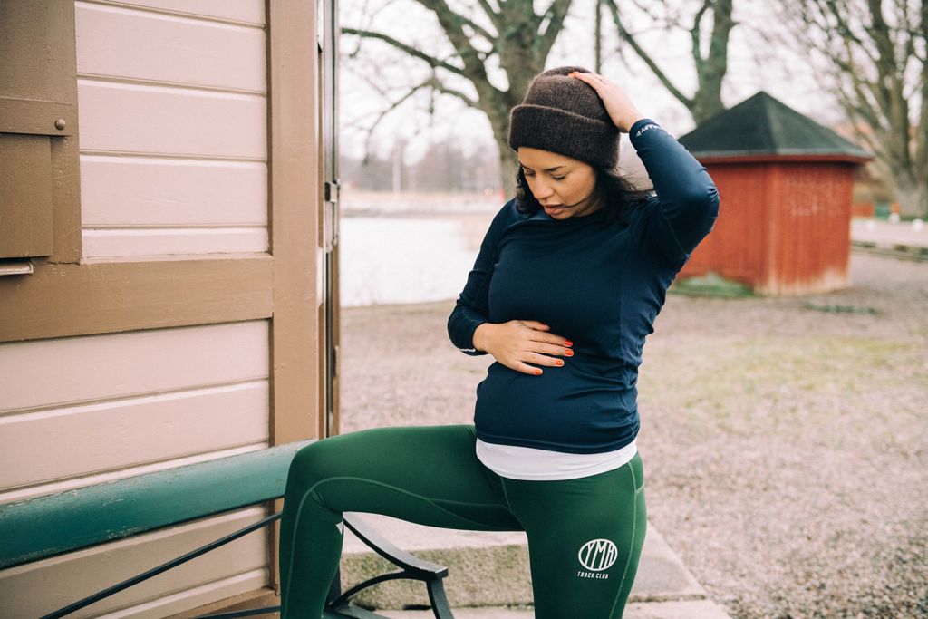 gravid kvinna i träningskläder utomhus