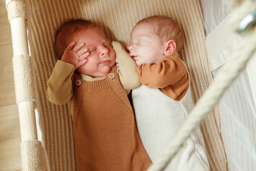 Två tvillingar sover tillsammans i en barnsäng